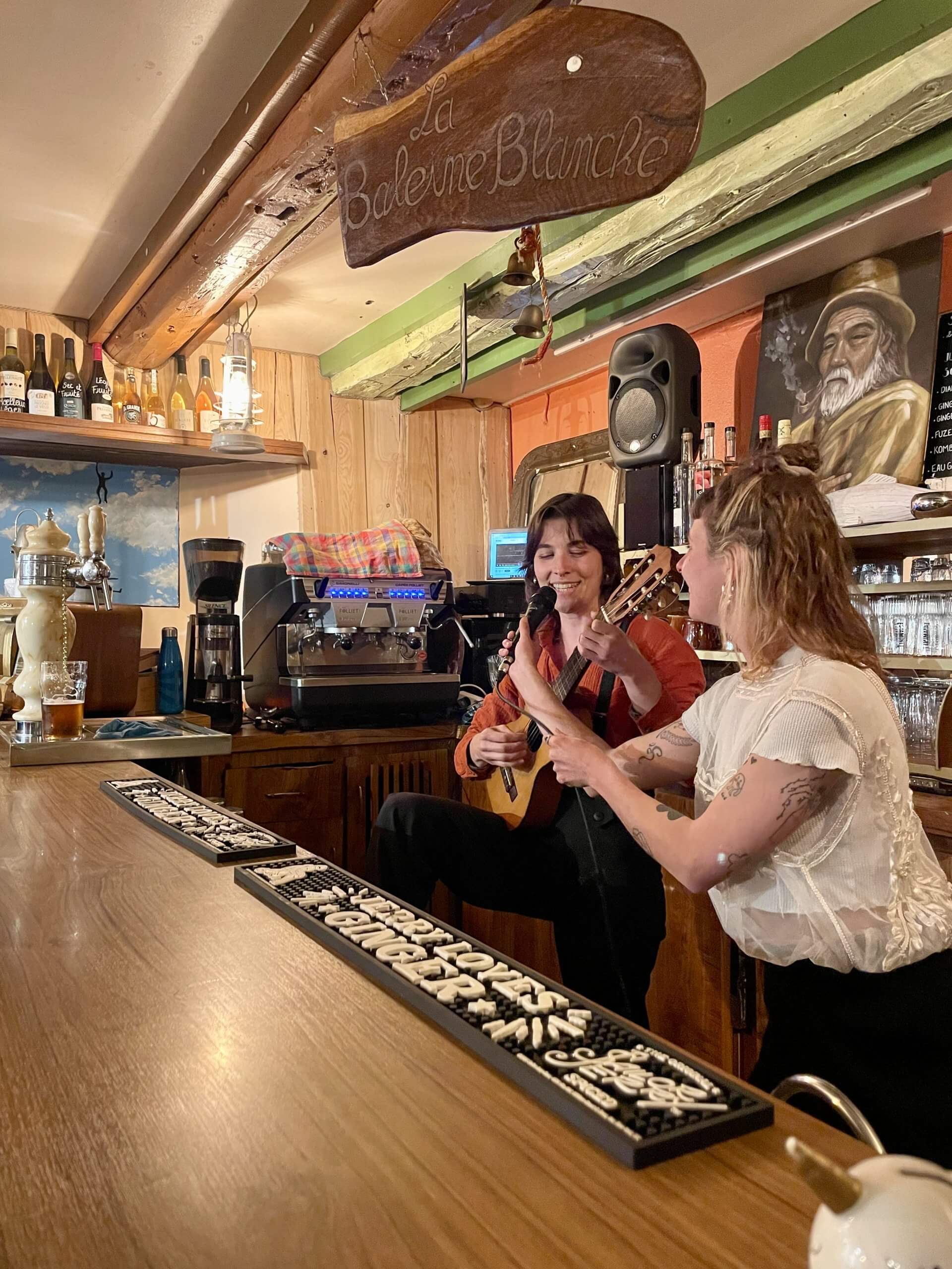 une femme joue de la guitare et chante, le micro est tenu par une autre femme